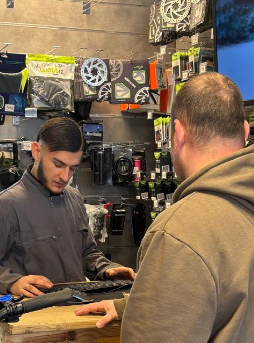 Un client et un technicien discutant autour d’un écran montrant un devis détaillé.